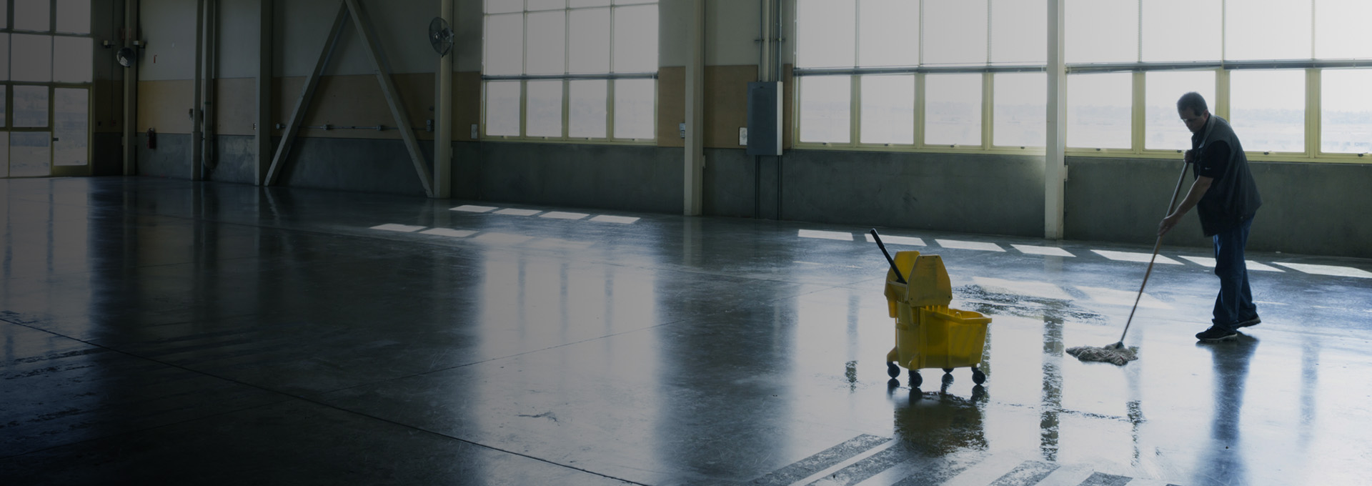 Man mopping the floor of warehouse