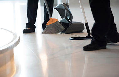 Two janitors sweeping and mopping the floor