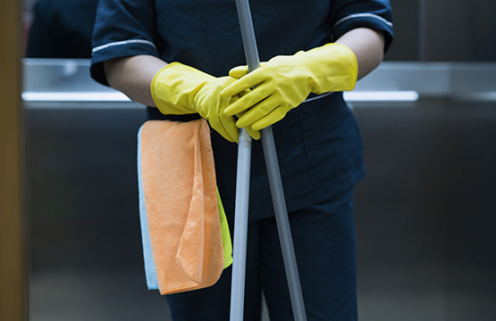 Cleaning person with yellow cleaning gloves and microfiber towel