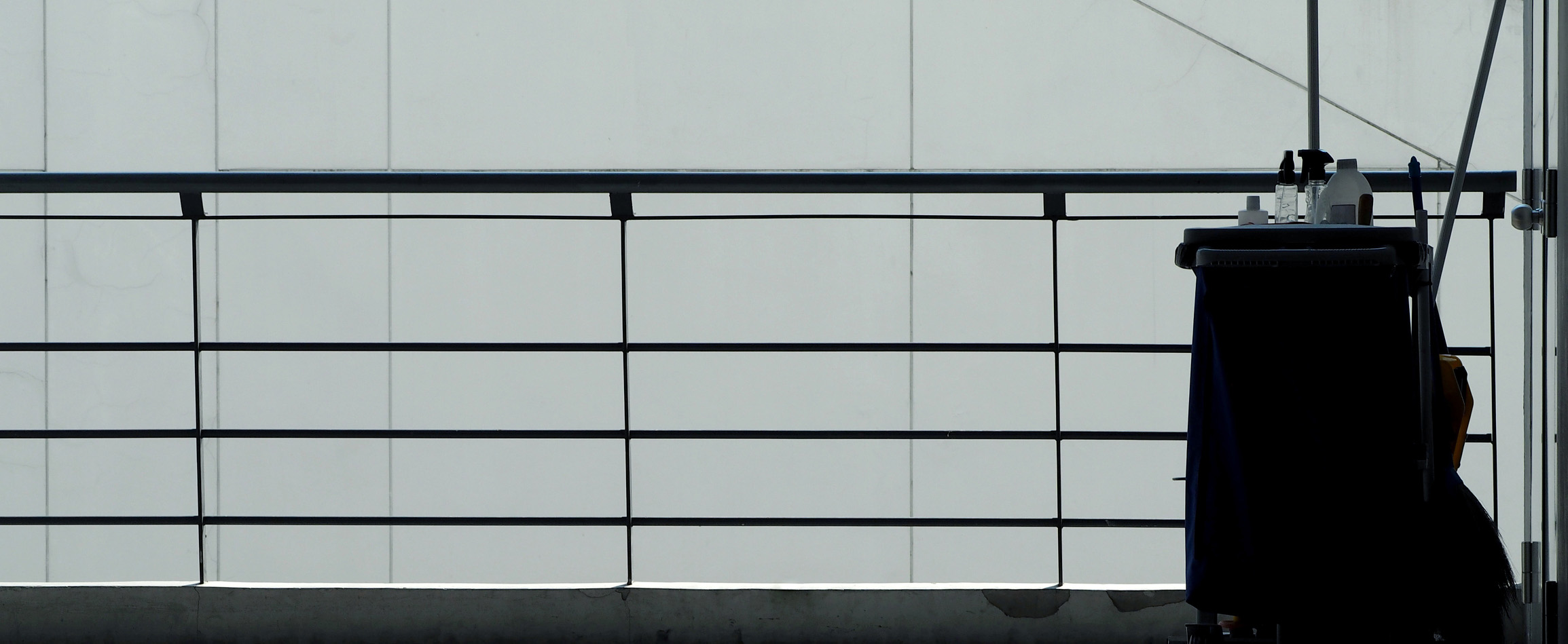 Janitorial cart situated beside railings in commercial space